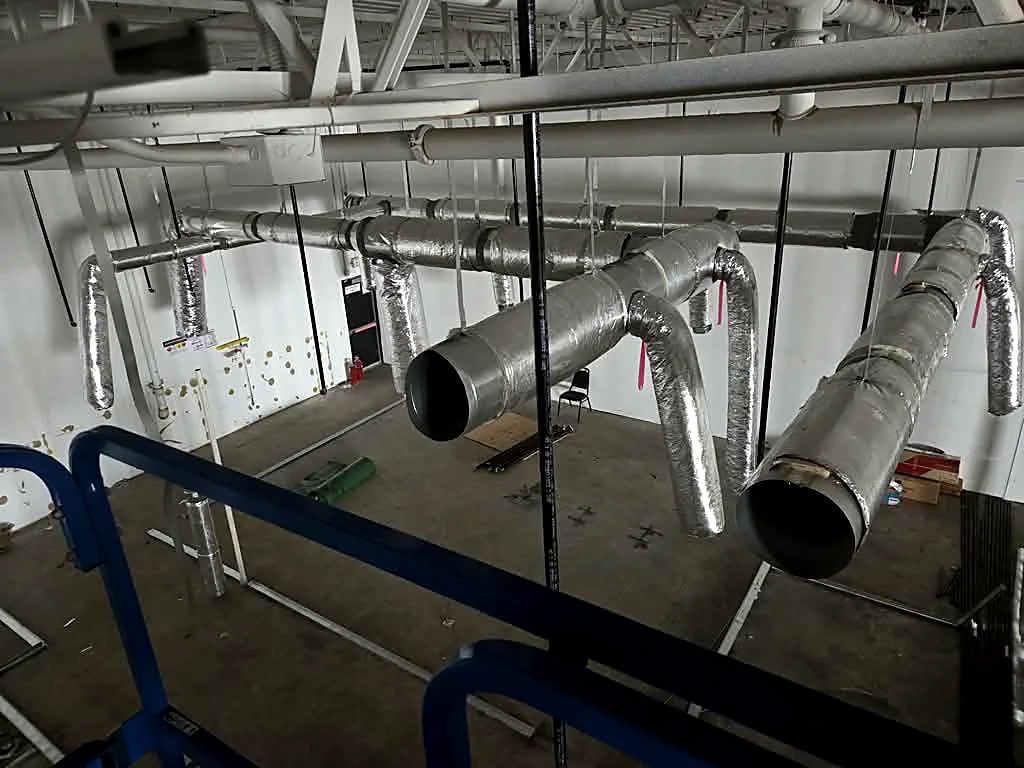 Round sheet-metal duct with insulated branch takeoffs, before the ceiling goes in